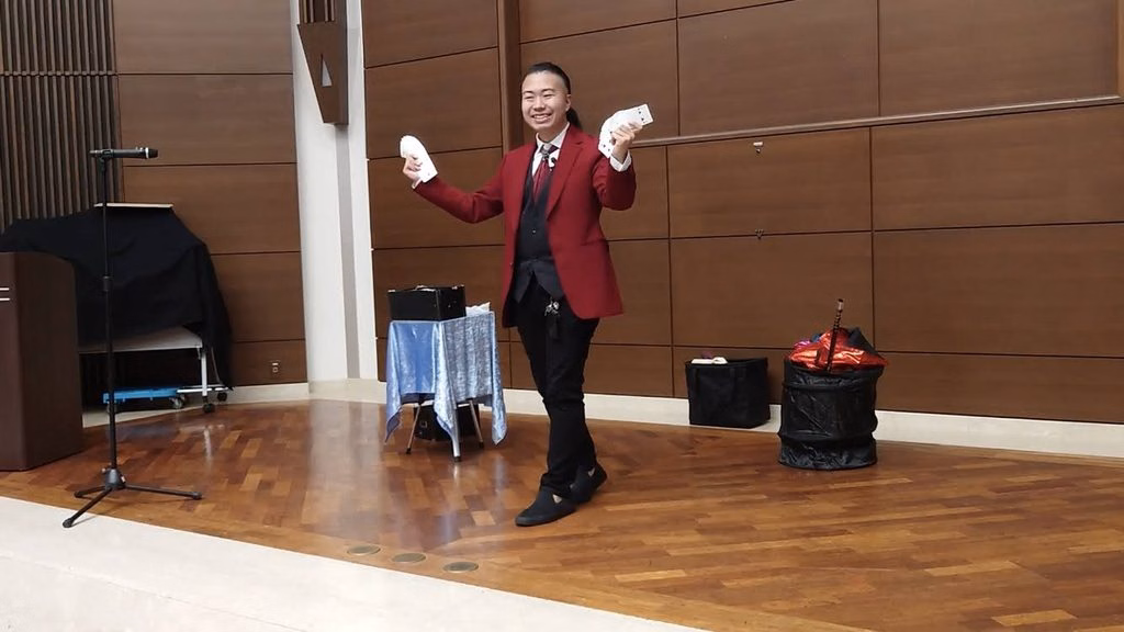 ステージでマジックを披露するマジシャン